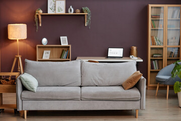 Background image of minimal home interior with comfortable grey sofa in living room against mauve accent wall, copy space - obrazy, fototapety, plakaty