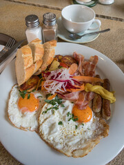 Desayuno con salchichas, bacon, verduras y huevos fritos