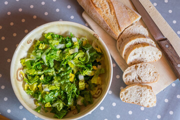 Bol con ensalada casera y barra de pan troceada