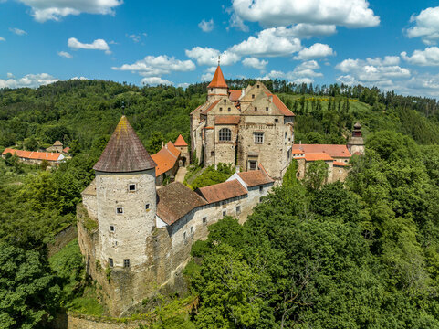 Aerial view of Pernstejn castle with Gothic palace red roof, rectangular and round towers, barbican, forward gun platform in Moravia