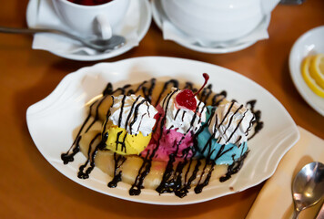 Caramelized Banana Split with three flavors of ice cream and whipped cream drizzled with chocolate...
