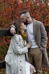 Happy family, beautiful couple on a fall picnic in the park, surprise date. Cozy autumn vibes, bright colours. Spending quality time together