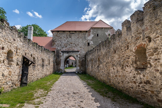 Zwinger with crenellated walls leading up to the medieval gate at Pernstejn castle