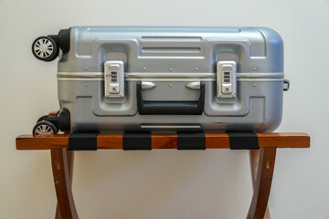 Suitcase on wooden luggage rack