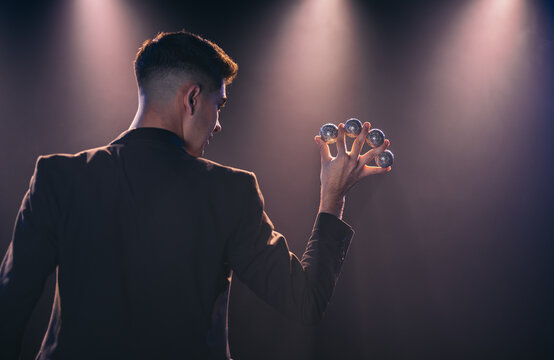 Man with balls between fingers