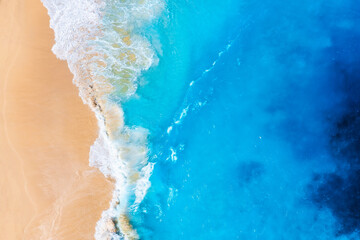 Fototapeta na wymiar Coast as a background from top view. Waves and beach. Aerial landscape. Azure water background from drone. Summer seascape from air. Vacation time.