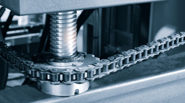 Gear chain drive shaft in conveyor belt is on production line. Timing chain of car, tensioners in engine. Industrial roller chain, technology. Team work, business industrial concept