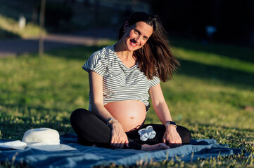 Pregnant woman sitting on picnic blanket