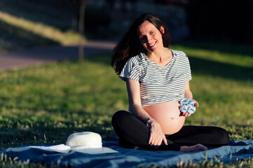 Pregnant woman sitting on picnic blanket
