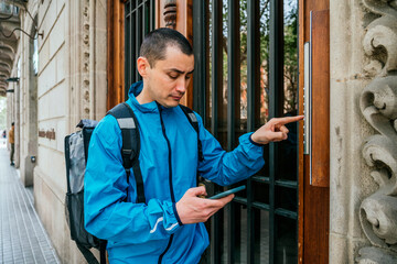 Delivery man with backpack calling intercom
