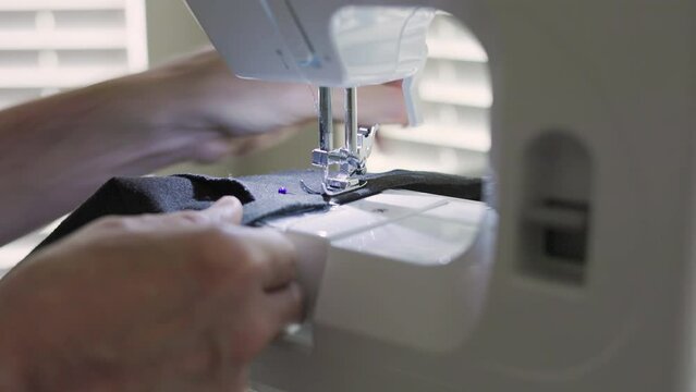 tailor sewing the new pants hem