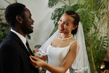 Waist up portrait of smiling black woman as beautiful bride meeting groom before wedding ceremony...