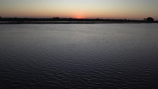 Panorama view of the river and sun hiding in the horizon.
