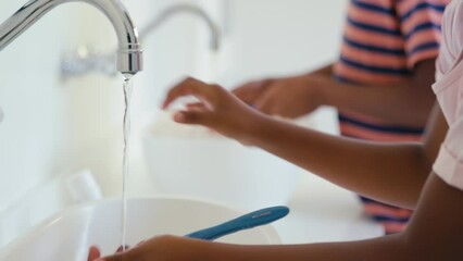 Brother and sister at home in bathroom brushing teeth with manual toothbrush - shot in slow motion