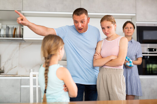 Family scene in kitchen, unpleasant conversation Parents stand face to face with daughter and scold for disobedience, unreasonable behavior