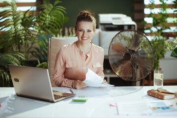 Portrait of happy modern woman worker in modern green office
