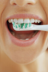 Closeup on woman brushing teeth