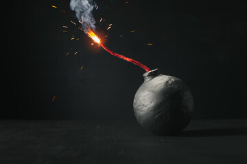 Round black bomb with lit fuse burning with sparks. Symbolizing fear, crisis, or dangerous violence.