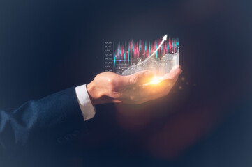 investment and finance concept, businessman holding virtual trading graph s on hand and word...
