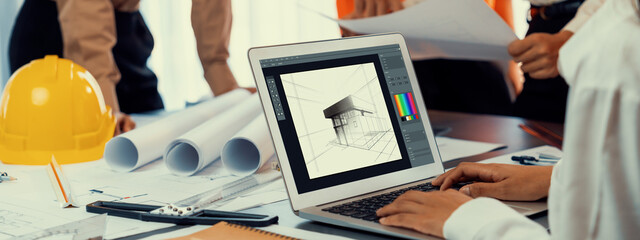 Engineer and architect working together brainstorming and designing blueprint using laptop working...