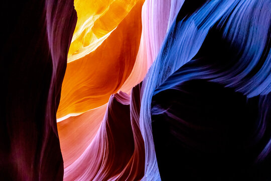 Abstract sandstone underground canyon cave with strong light and orange, red and purple colors.