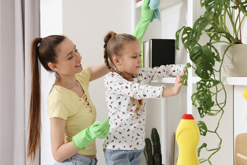 Spring cleaning. Mother and daughter tidying up together at home
