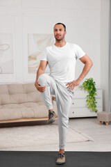 Man doing morning exercise on fitness mat at home