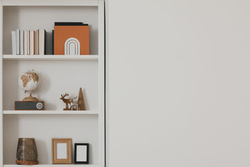 Stylish shelves with different decor elements indoors, space for text. Interior design