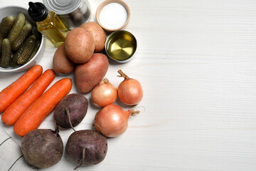 Cooking vinaigrette salad. Many fresh vegetables and other ingredients on white wooden table, flat lay. Space for text