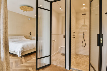 a bathroom with a bed in the corner and shower doors open to reveal a large walk - in shower area
