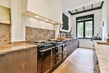 a kitchen with an oven, stove and sink in the center of the room that has wood flooring on the walls