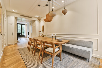 a dining room with wood flooring and white trim on the walls there is a wooden table that has two chairs in it
