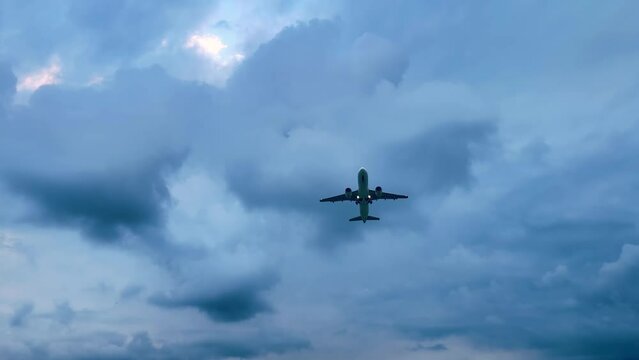 Large passenger airplane, airliner is taking off, gaining altitude and flying in the cloudy sky in the evening. Transportation, journey, flight and tourism concept