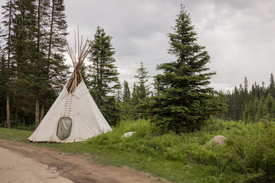 A wigwam tent is standing in the forest. Active recreation in the mountains. Hiking, camping, shelter in the Rocky Mountains, Alberta, Canada