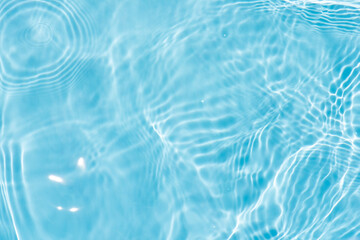 Blue water with ripples on the surface. Defocus blurred transparent blue colored clear calm water surface texture with splashes and bubbles. Water waves with shining pattern texture background.