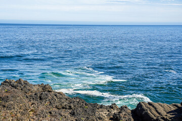 Fototapeta na wymiar View to the Pacific Ocean from the Oregon coastline, USA. Waves hitting the rocks.