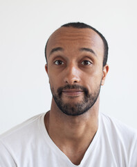 Fototapeta premium A young unshaven man on a light gray background.