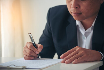 Businessman hand using pen signing on new contract to starting projects in conference room. Close up business manager man hands sign contract legal document in meeting room. Business agreement concept