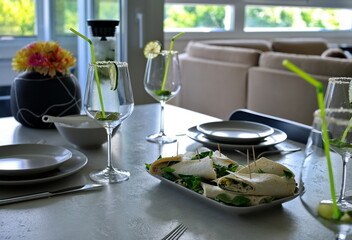 Plate with tortilla and glasses for cocktail on a table at home