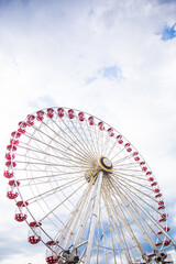 Ferris wheel with red seats against a blue sky