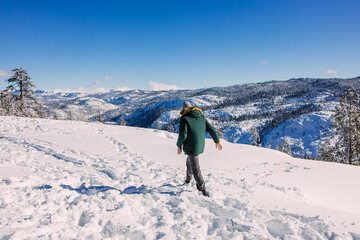 Fototapeta na wymiar Man walking in the snow in the mountains