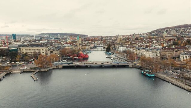Aerial footage Hyper lapse of the Zurich old town where the Limmat river joins lake Zurich with tramway running on a bridge in Switzerland largest city. aerial view drone of Zurich city. cinematic.