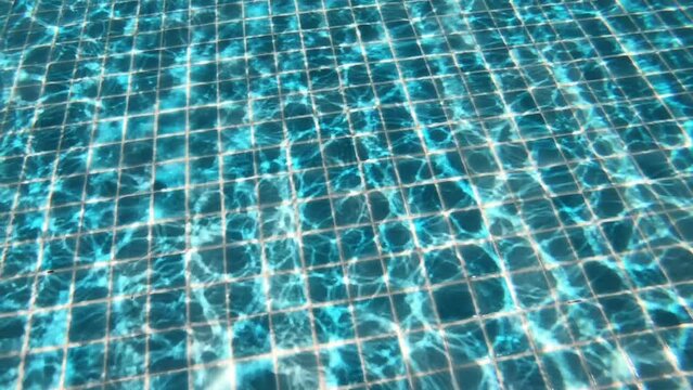 diving into the water on blue swimming pool, beautiful pool texture background, slow motion scene