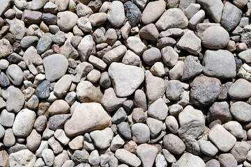 Abstract background with grey dry stones, cobblestones, gravel. Gravel texture or background for design, for banner. Real grunge background texture and small stone. Close up, top view.