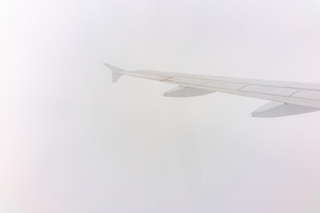 View from the airplane window at a beautiful cloudy sky and the airplane wing