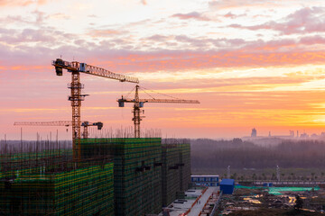 The construction site is in the morning.  In the morning, the tower hangs over the construction site.