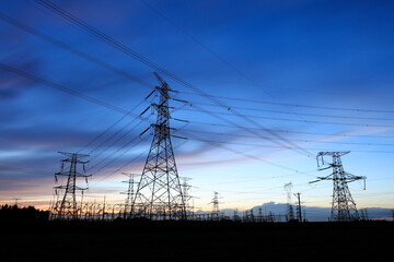 In the evening, the silhouette of high voltage towers