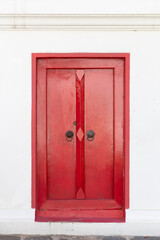 Antique red painted wooden door It is commonly seen in old buildings or temples in Asia such as Bangkok, China, Vietnam, Myanmar.