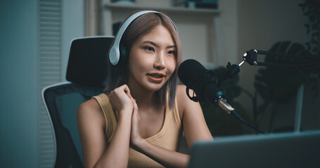 Cheerful Young podcaster use microphone during online podcast in studio