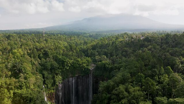 Aerial view of Coban Kapas Biru waterfall with Semeru Volcano in the background. East Java, Indonesia